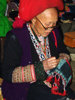Red Dzao woman sewing at Sapa market
